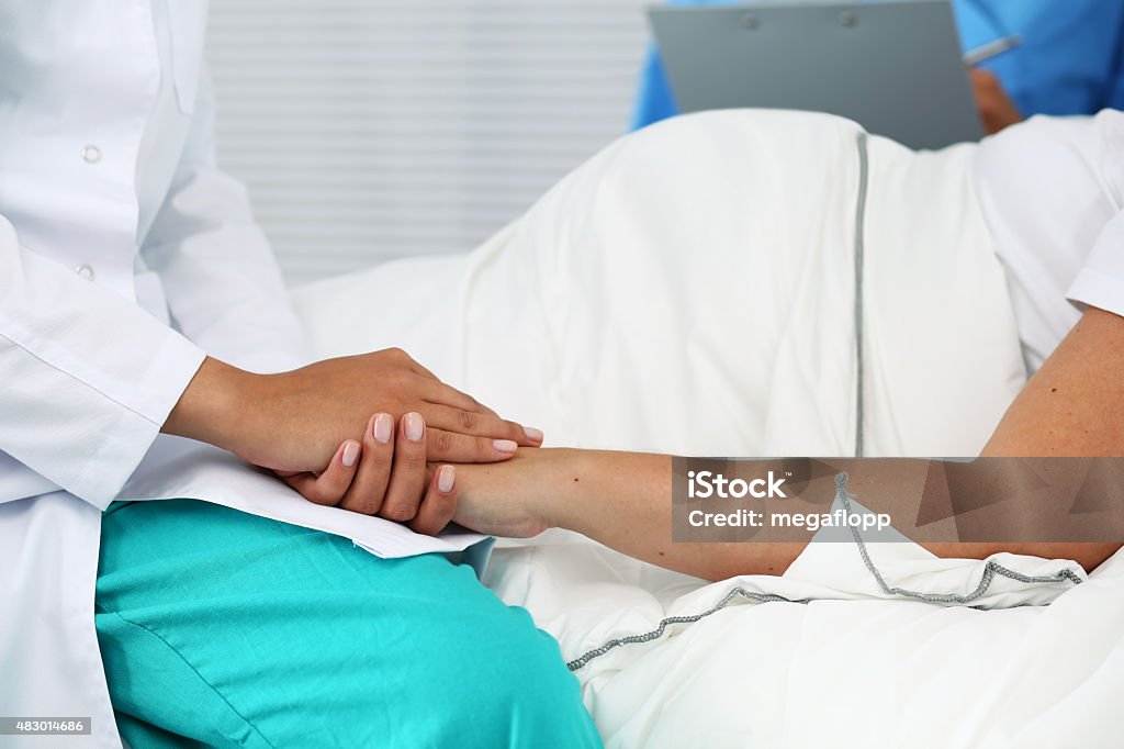 New life of abortion concept Friendly female medicine doctor hands holding pregnant woman's hand lying in bed for encouragement, empathy, cheering and support while medical examination. New life of abortion concept Pregnant Stock Photo