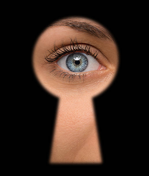 Peeking Close up of female eye looking through a keyhole peep hole stock pictures, royalty-free photos & images