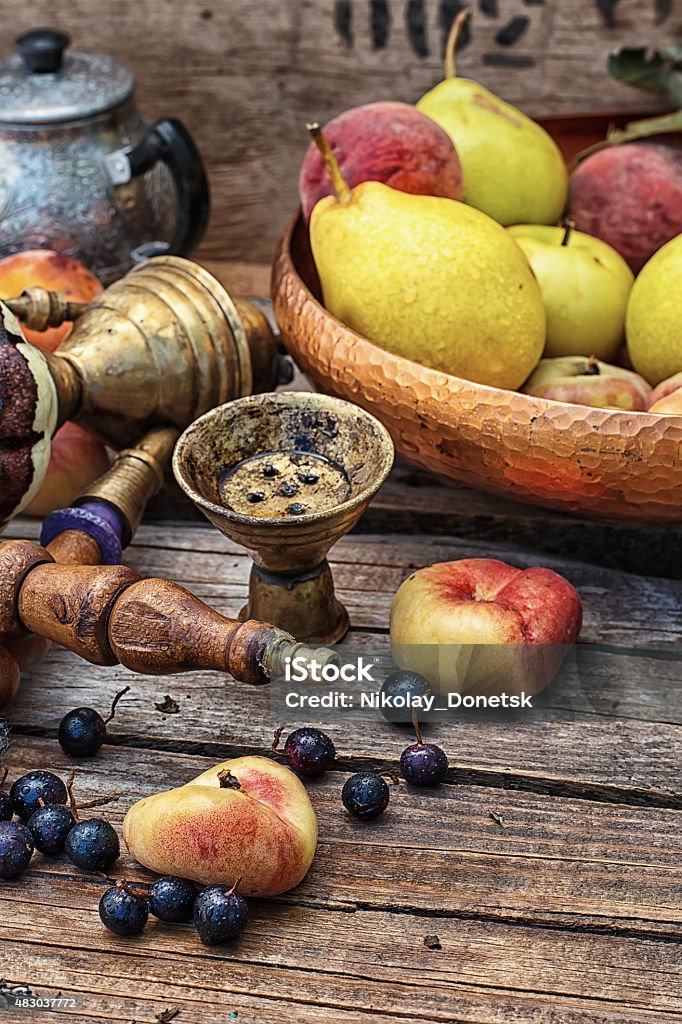 hookah Details were worked hookah on the table amid fresh peaches.Photo tinted. 2015 Stock Photo