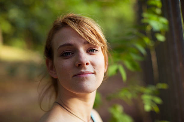 Portrait of a brunette woman 35-40 years old in a park among greenery on a city street.