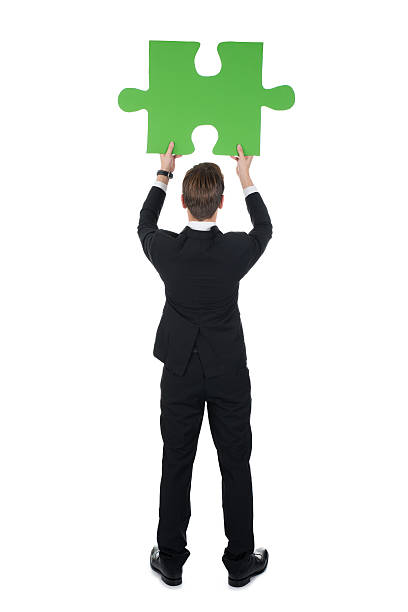 istock Businessman Holding Green Puzzle Piece 483044458
