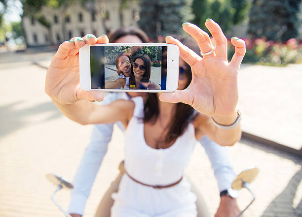 istock Happy couple showing smartphone screen while making selfie  outdoors 483045336