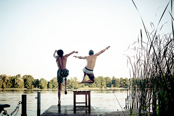 istock carefree summer day: teenagers jumping into a lake 483046077