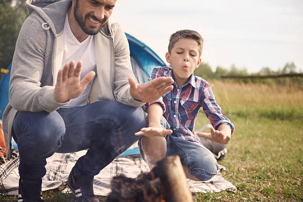 istock Father and son crouching by the campfire 483047548