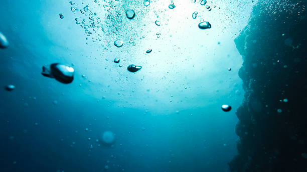 Bulles dans l'eau sur un fond bleu, photographie sous-marine - Photo