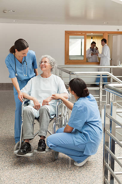 istock Old woman in wheelchair talking with nurses 483049863