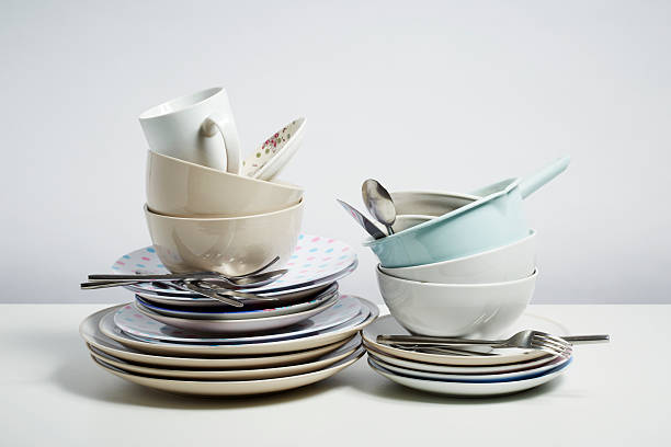 istock Dirty dishes pile needing washing up on white background 483050075