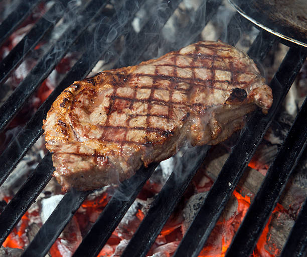 beef steak cooking on an open flame grill