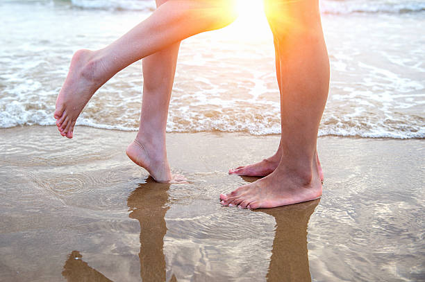 istock Young couple legs on the beach sand. 483053556