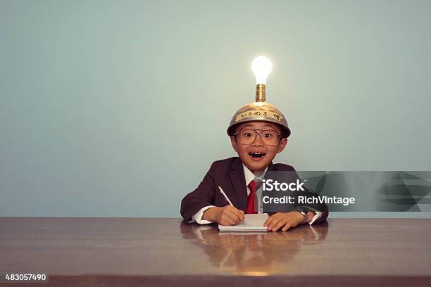 Surprised Japanese Business Boy Wearing Lit Up Thinking Cap Stock Photo - Download Image Now