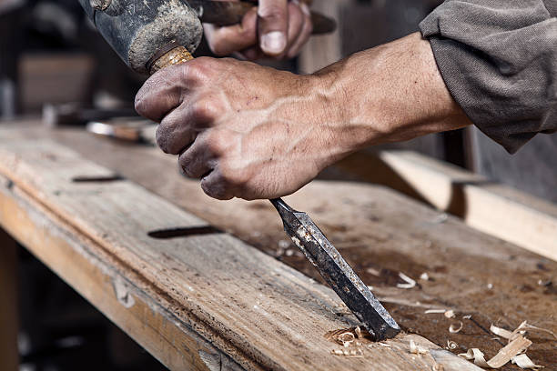 istock Hands of carpenter with chisel in the hands 483060022