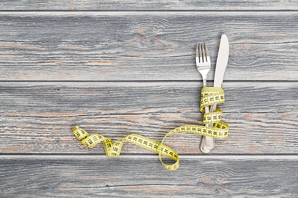 istock Knife and fork wrapped in tape measure. 483064356