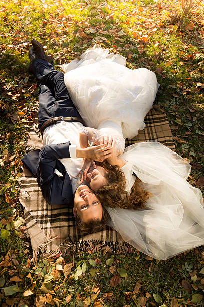 istock just married couple lying on yellow leaves at park 483068732