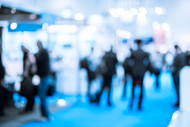 People at a Trade Exhibition Defocused shot of crowd  on exhibition. Purposely blurred with a lens. tradeshow photos stock pictures, royalty-free photos & images