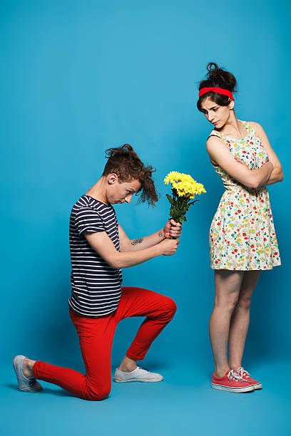 istock Surprised young woman getting flower from guy 483069782