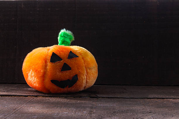 istock Face pumpkin toy on a wooden background 483074390