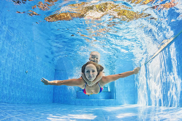 mother with child swimming and diving underwater in pool - baby swim under water bildbanksfoton och bilder