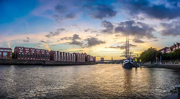 Historic town of Bremen with Weser river with dramatic clouds at sunset, Germany