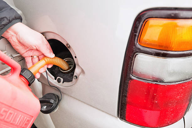 intrecciato veicolo riempimento serbatoio del carburante con portatile possibile - gas can stranded gasoline car foto e immagini stock