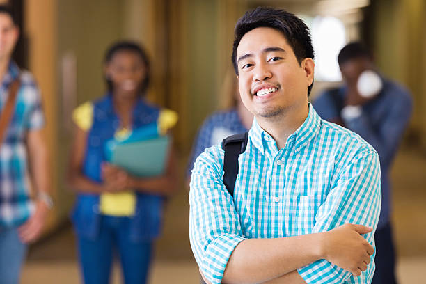 istock College student posing on campus in front of other students 483079383