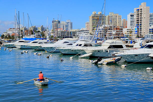 Contrasts: Simple fishing boat and fancy yachts in the port of Punta del Este, Uruguay.