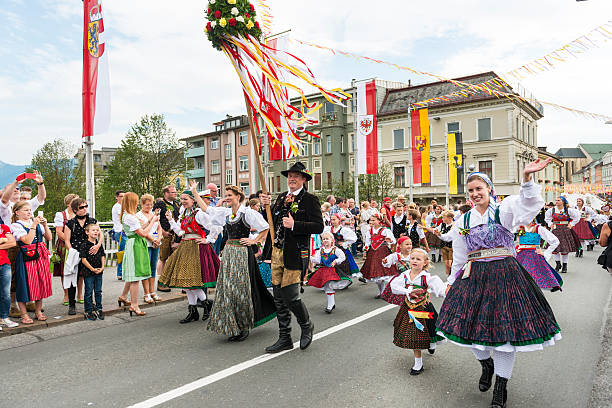 Villach Church Day Villach, Austria - August 1, 2015: On the main bridge over Drava River the costume parade - man and women in national costume parading past many spectators on sides applauding and taking photos. Houses in background and provincial flags. highlight of the festival is the National Costume parade. villach stock pictures, royalty-free photos & images