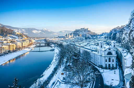 Salzburg skyline with Festung Hohensalzburg and river Salzach in winter