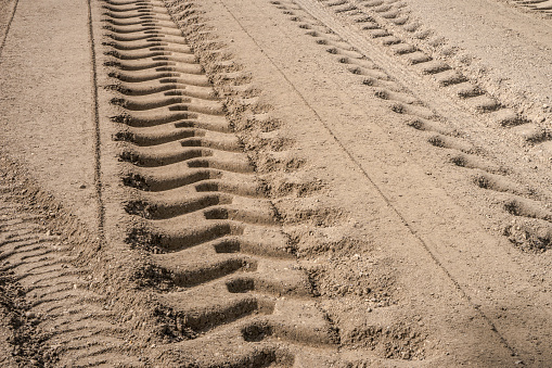 Tire tracks left by road construction equipment  on sand layer base