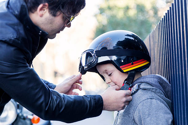young loving dad fastens helmet to his son before travel