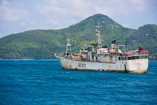 Mahe, Seychelles - January 11, 2015: Old Chinese cargo ship sailing in the Indian ocean near Seychelles islands