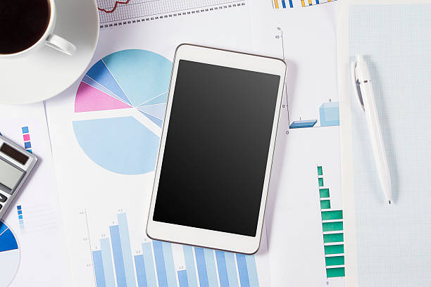 istock Digital Tablet on Office Desk with Business Graphs and Charts 483084908