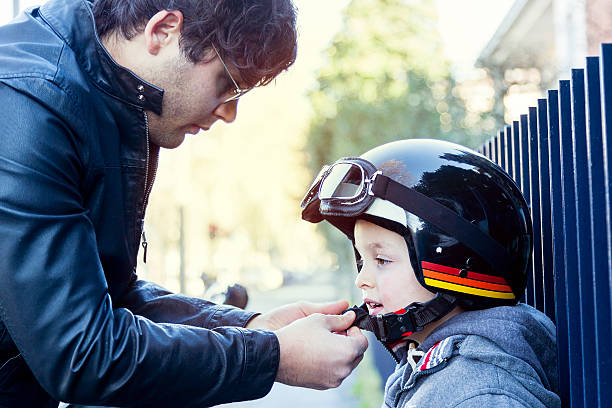 istock young loving dad fastens helmet to his son before travel 483087464