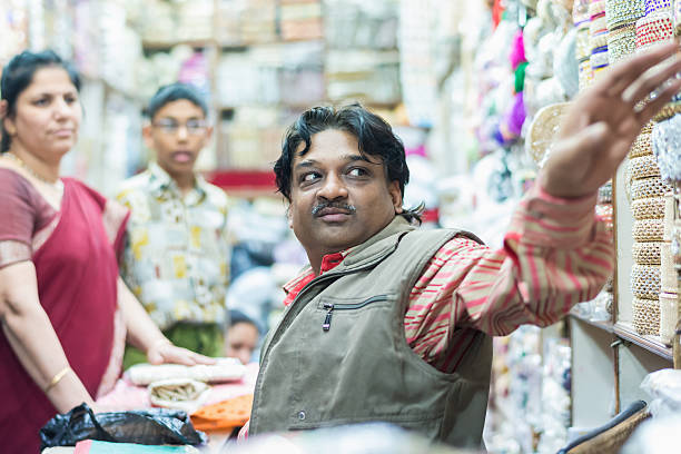 pequena loja proprietário servir os seus clientes - consumerism indian ethnicity india delhi imagens e fotografias de stock