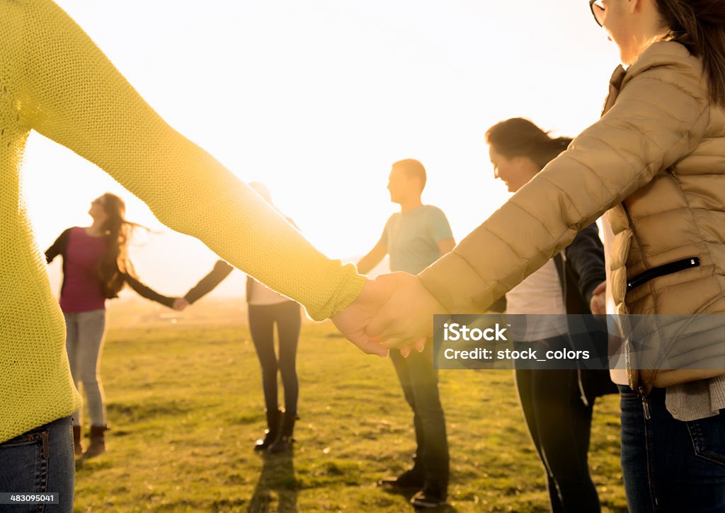 togetherness friends holding hands in summer field, unity and friendship concept. Sharing Stock Photo