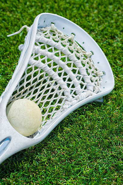 istock White ball and white Lacrosse stick on artificial turf 483096176