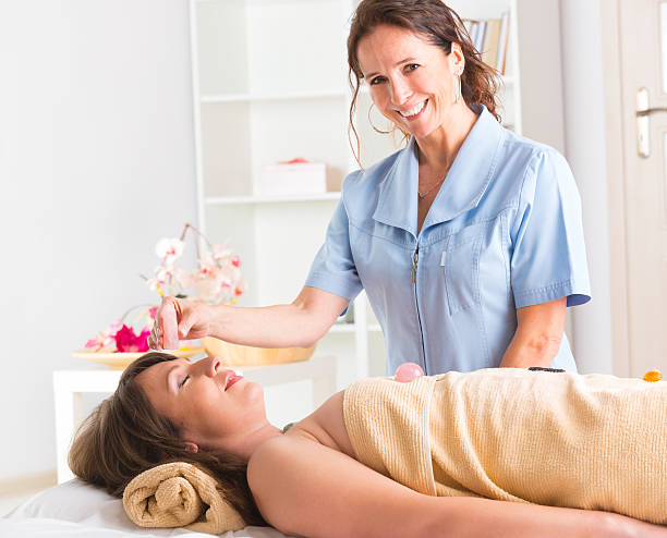 lithotherapy - reiki alternative therapy massaging women photos et images de collection