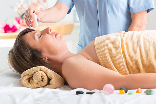 lithotherapy - reiki alternative therapy massaging women photos et images de collection