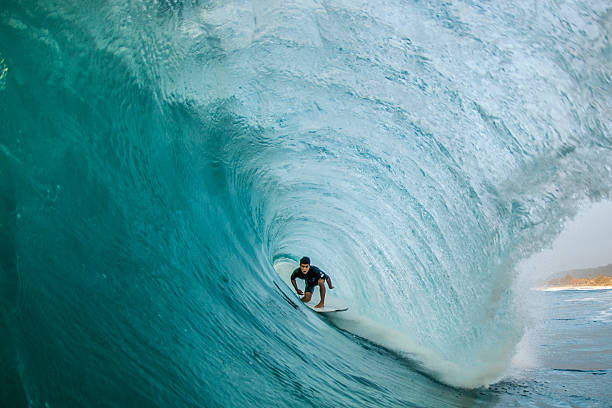 Tunnel Vision A professional surfer finds himself perfectly pitted deep within a North Shore barrel surfing photos stock pictures, royalty-free photos & images