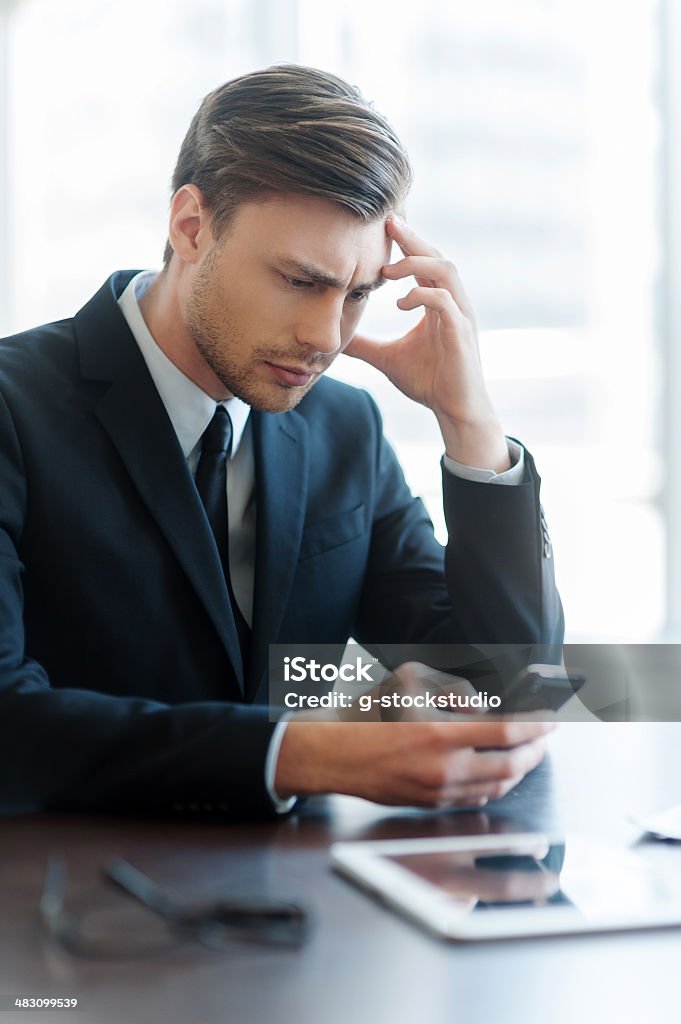 Man typing a message. Cheerful young man using mobile phone while coffee break in office Adult Stock Photo