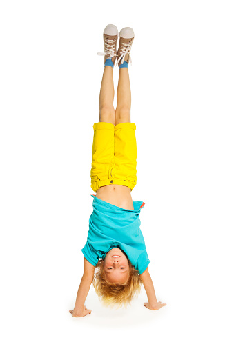 8 years old boy standing on hands upside down isolated on white