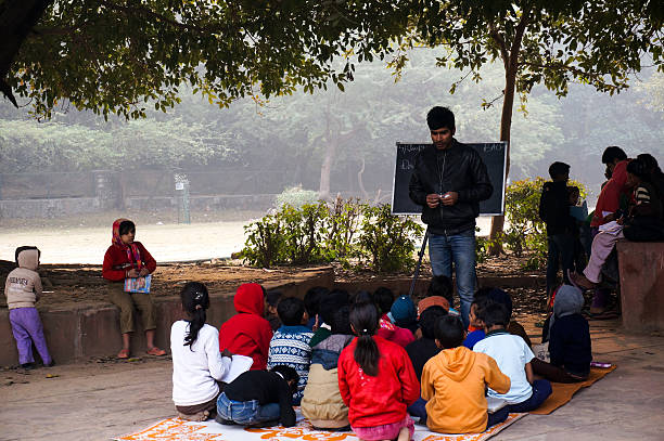 Open air classroom at hauz khas Delhi, India: 4th Jan 2014 - Poor children being taught in an open air classroom by volunteers. Classes like this (madrasa) are often held at the hauz khas village in Delhi India. This is to impart basic education to those who are unable to afford traditional schools. madressa photos stock pictures, royalty-free photos & images