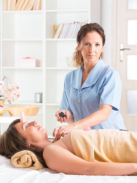 lithotherapy - reiki alternative therapy massaging women photos et images de collection