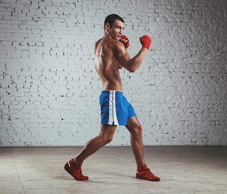 Asian businessman with red boxing gloves fighting isolated over white background