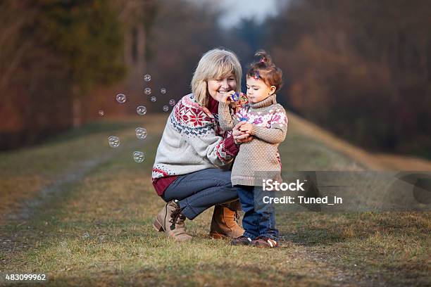Grandmother And Granddaughter Blowing Bubbles Stock Photo - Download Image Now - Bubble Wand, Grandmother, Baby - Human Age