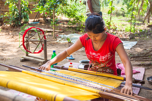 Tripura, India- May 2, 2011:  Tribal woman weaving cloths on a hand loom. The woman belongs to the \