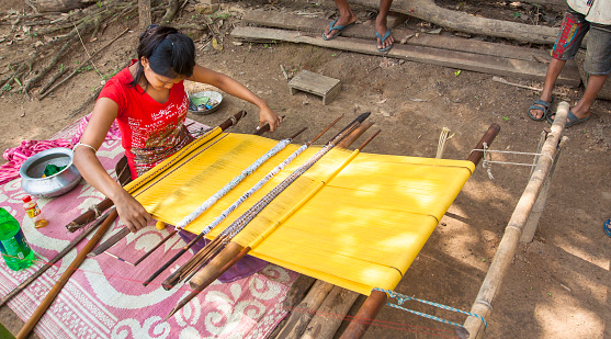 Tripura, India- May 2, 2011:  Tribal woman weaving cloths on a hand loom. The woman belongs to the \