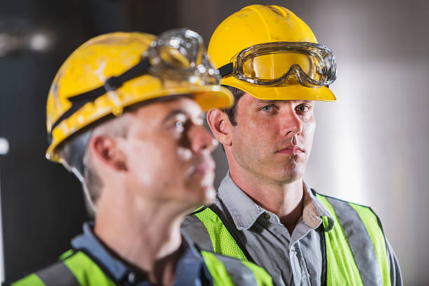 istock Two men wearing hardhats, vests and safety glasses 483101596