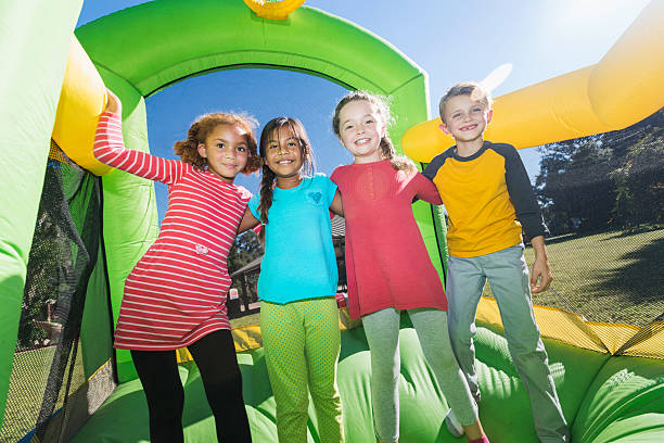 istock Four multi-ethnic children playing on bouncy castle 483101786