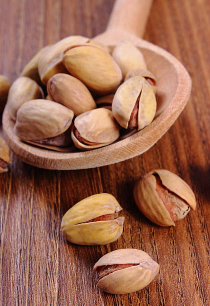 istock Pistachio nuts with spoon on wooden table, healthy eating 483104076