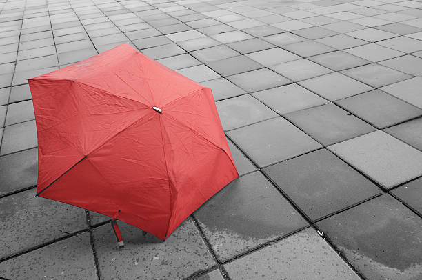 istock Red umbrella on the floor wet after rain. 483104836